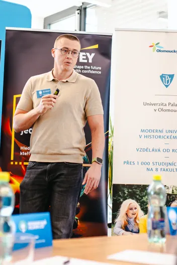 Adam Kolek s mikrofonem při přednášce